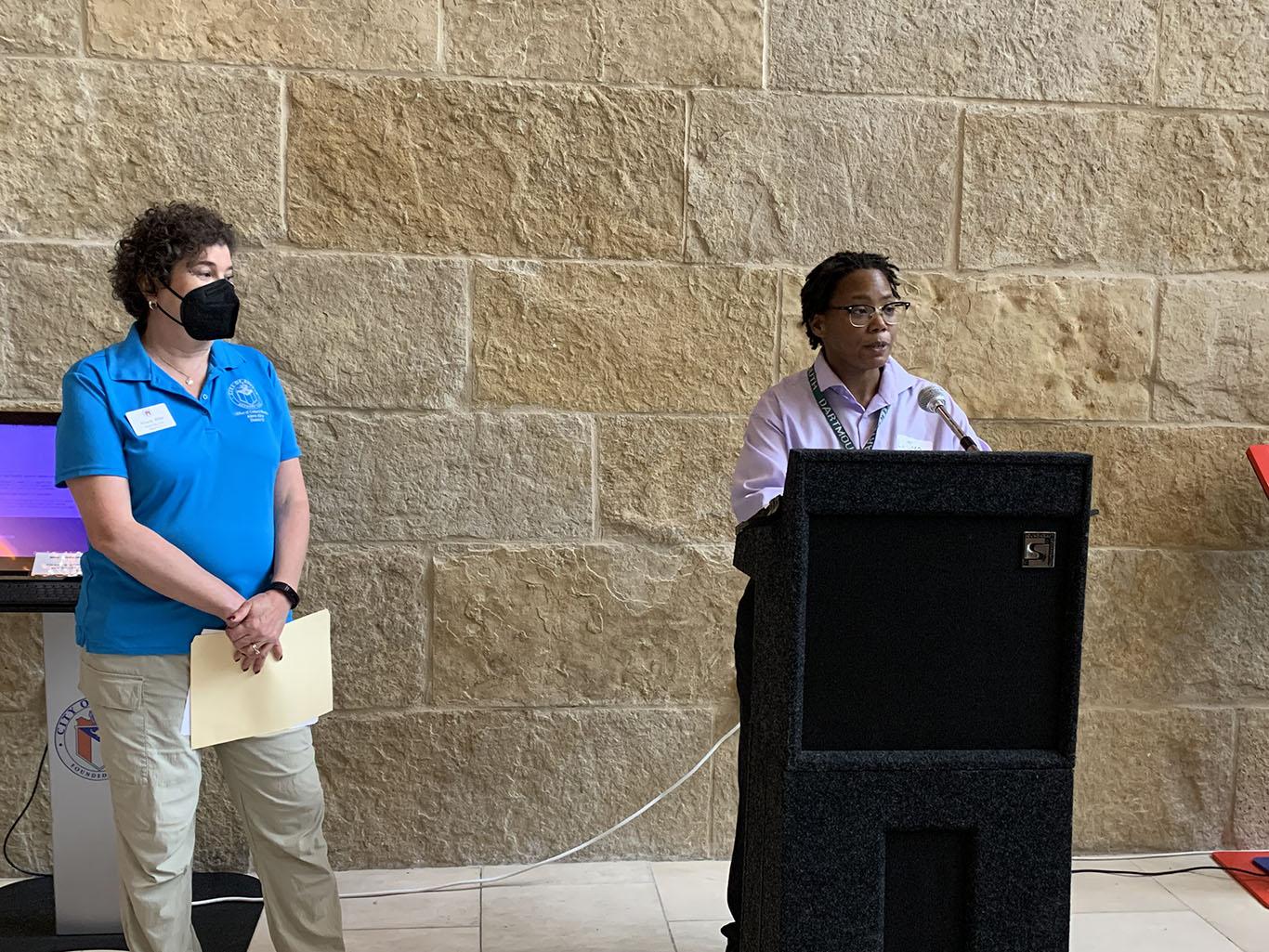 LaJuan Tucker (R) delivers opening remarks and introduces Mayor Pro-Tem Alison Alter (L). Photo Credit: Weston Rose. LaJuan Tucker (R) delivers opening remarks and introduces Mayor Pro-Tem Alison Alter (L). Photo Credit: Weston Rose.