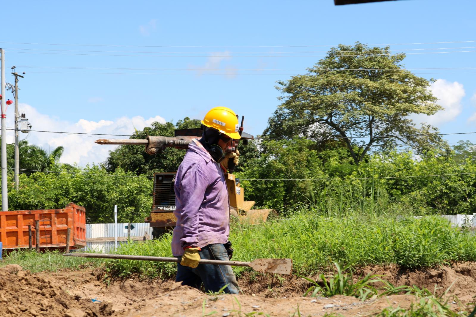 Man wearing hard hat and carrying tools