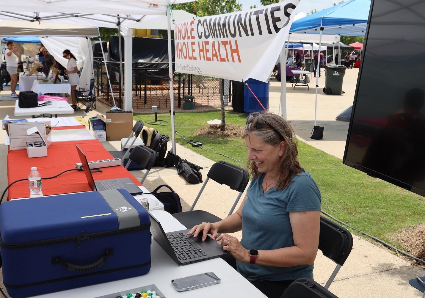 Kerry Kinney from the Maseeh Department of Civil, Architectural and Environmental Engineering demonstrates one of the indoor air quality measurement tools used by WCWH at Del Valle Day 2023