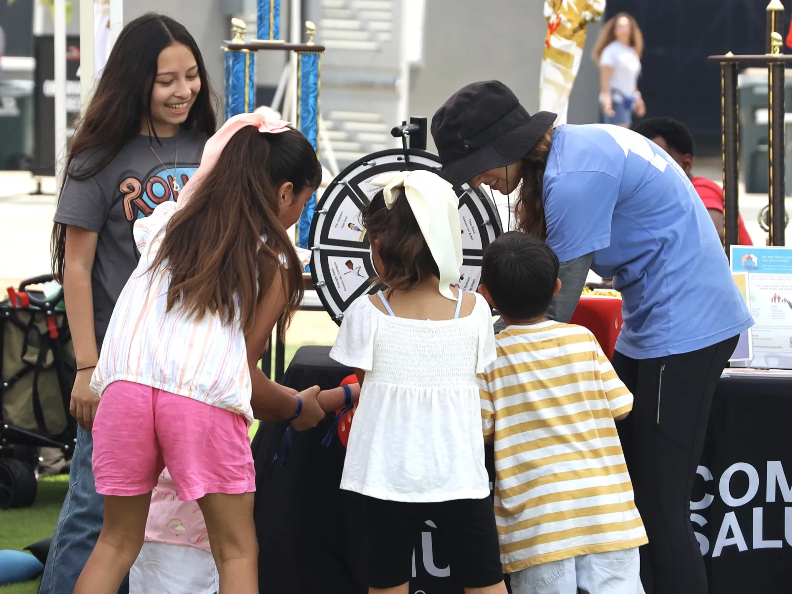 Whole Communities–Whole Health Research Coordinator Sarah Smith (in hat), with children at Del Valle Day, June 2024. Whole Communities–Whole Health Research Coordinator Sarah Smith (in hat), with children at Del Valle Day, June 2024.