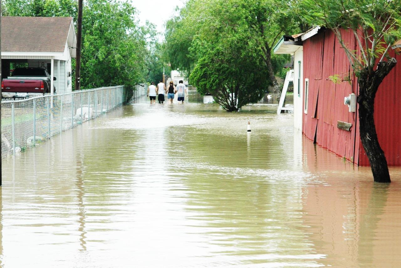 Family walks home through flood waters after Dolly