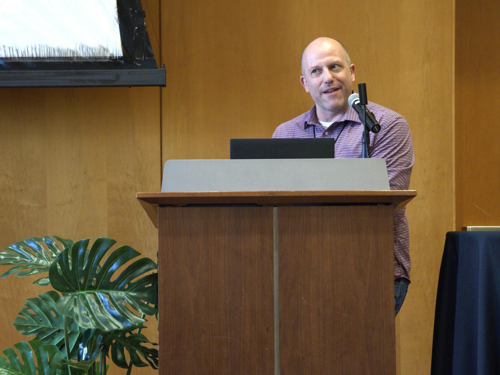 Whole Communities–Whole Health chair and panel moderator Mike Mackert stands at a podium and speaks at the WCWH Symposium at UT Austin on February 6, 2026.