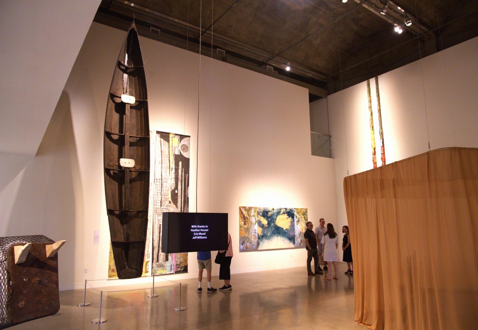 A wide shot of the main room of the Visual Arts Center from opening night of the "How to Grow the Cowpea" exhibition. September 4, 2026; UT Austin campus