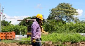 Man wearing hard hat and carrying tools