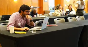 Flash-funding award recipient Akram Al-Turk, a research associate at the Moritz Center for Societal Impact at the Steve Hicks School of Social Work, works on his grant proposal at the WCWH Symposium, February 7.