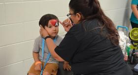 A child gets his face painted at Community Resource Day; April 2024