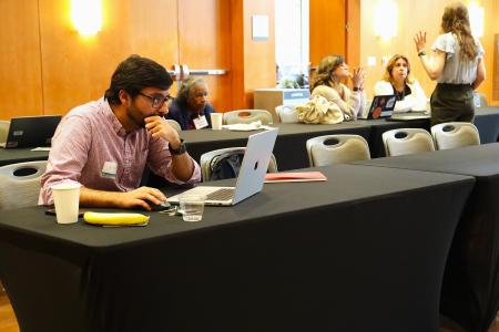 Flash-funding award recipient Akram Al-Turk, a research associate at the Moritz Center for Societal Impact at the Steve Hicks School of Social Work, works on his grant proposal at the WCWH Symposium, February 7.