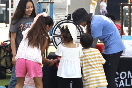 Whole Communities–Whole Health Research Coordinator Sarah Smith (in hat), with children at Del Valle Day, June 2024.