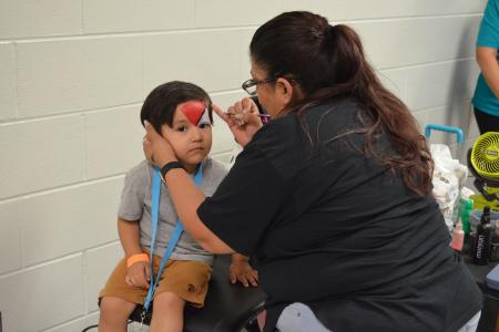 A child gets his face painted at Community Resource Day; April 2024